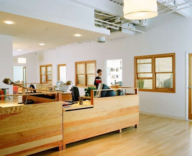  Film Production Office, Santa Monica: This is the general office area for a film production company. My client wanted the office to have an old Soho loft character, raw, and unpretentious. I chose construction quality Douglas Fir for the desks to help create that character. The grain of the wood was used as a decorative element. The interior windows bring light into the central office, and the wood frames echo the material of the desks. I used rice paper pendant lamps from IKEA throughout, giving a warm glow and a casual appeal. Photo: Dominique Vorillon