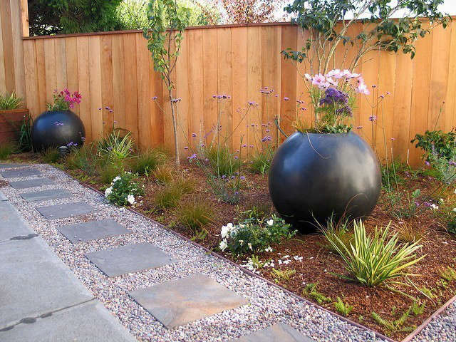  Orb Garden: Orbs create punctuation and angles create 3 different levels in this garden. Bluestone mixed with gravel creates a hopskotch area for the kids and a place for toy trucks while the concrete patio is for adults. Photo: Beth Mullins
