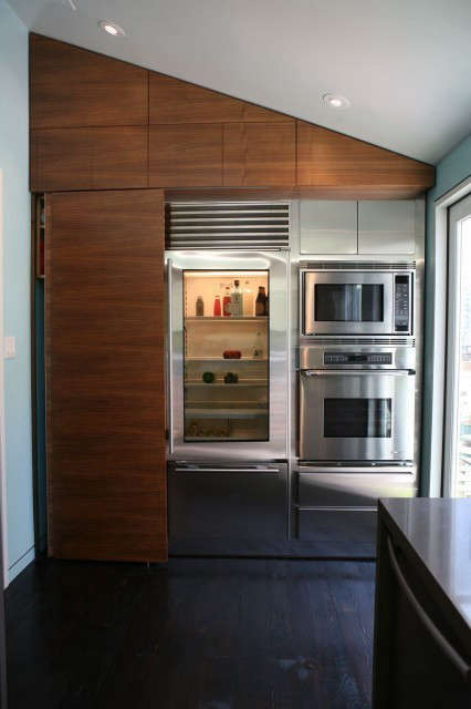  Noe Street Kitchen: A sliding walnut panel (left) hides a stacked washer and dryer, and glides past the Subzero glass front refrigerator. Photo: eurydice galka