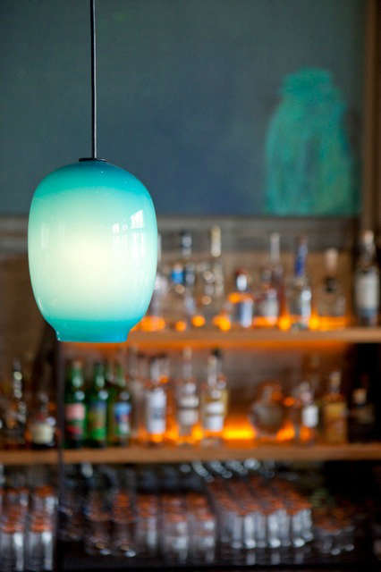  Bar Pendants: Custom turquoise blue glass pendants are by local glass blower Lee Miltier. The simple raw steel and wood back bar features amber LED lights which graze the surface of the concrete walls. Photo: Eurydice Galka