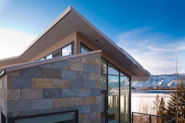  JACKSON HOLE RESIDENCE: This Residence is located on a steeply sloping hillside overlooking a mountain meadow and the Grand Teton Mountain Range. The house is sited along the slope of the site and it realigns itself with the contours of the site, optimizing solar orientation and desirable views. The traditional alpine pitched roof profile is sheared to create a slit of light which activates the space and creates a Circulation Corridor which runs through the entire building. Photo: David J. Swift