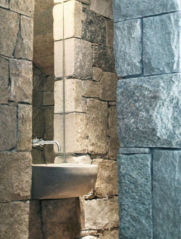  powder room: a custom concrete sink cantilevered from a stone niche