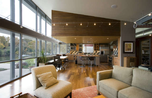  Lake House Remodel: Staying within the footprint of a tear-down ranch style house, the new home was given a modern appreciation for lakeside views with commercially scaled storefront windows, steel beam and posts, and a brise soleil to filter daylight into the living spaces.