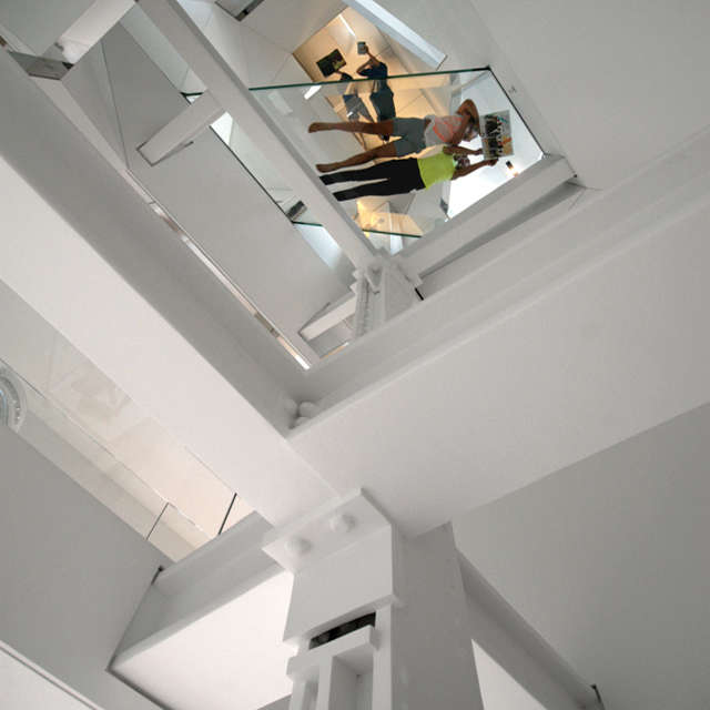  Stairwell_viewed from Entry: From the entry, the stairwell ascends through all floor level sof the penthouse. The original riveted steel structure from \1895 threads through the shaft and slips past the structural glass bedroom bridge and the glass floor of the Attic level.