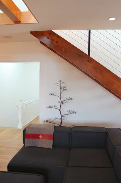  San Francisco Condo &#8\2\1\1; Living Room Relocation: A former dining room and office were converted into the new living room. A reclaimed Douglas fir staircase leads to the new master suite above. Glass in the master bedroom floor and a skylight above the stair allow natural light to filter into this formerly dark space.