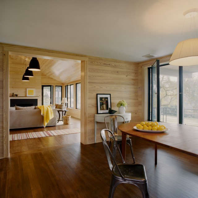  Weekend House Kitchen to Dining Room: Renovated dining area flows through to the new living room. Stained wide plank pine boards are used on the walls. Photo: Karen Cipolla