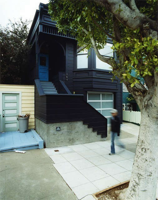  Clipper Street Residence SFCA: Clipper Street Residence: The gingerbread of the existing Victorian house is collected under a blue-black monochrome. Space Invader makes his mark on the architectural concrete base for the tongue of the new stair. The cyan painted door calls out entry to the residence above, a new service station door to the garage and studio below. Photo: Todd Hido