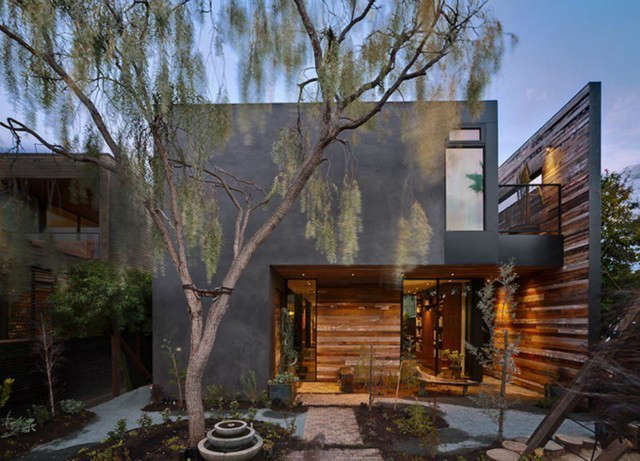  S and S Residence: The S & S Residence was designed for a young family in Venice, CA. To take advantage of the narrow lot, the design uses a series of screens and walls that ensure privacy from the street but allow openness within the site. A gray plaster façade catches shadows from the trees and contrasts with the multicolored, reclaimed wood siding of the southwest wall. Photo: Barry Schwartz and Marmol Radziner