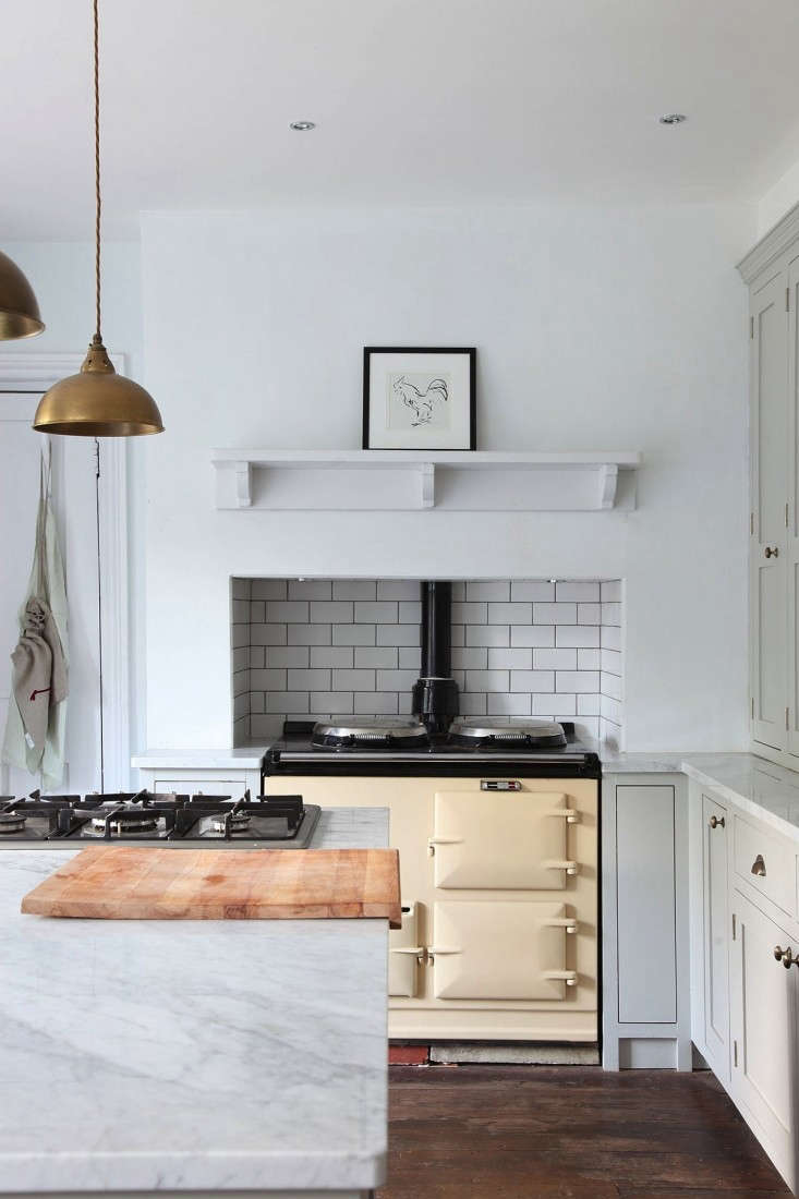 A Minimalist English Kitchen is outfitted with a traditional Aga range (and an extra cooktop, located on the island).