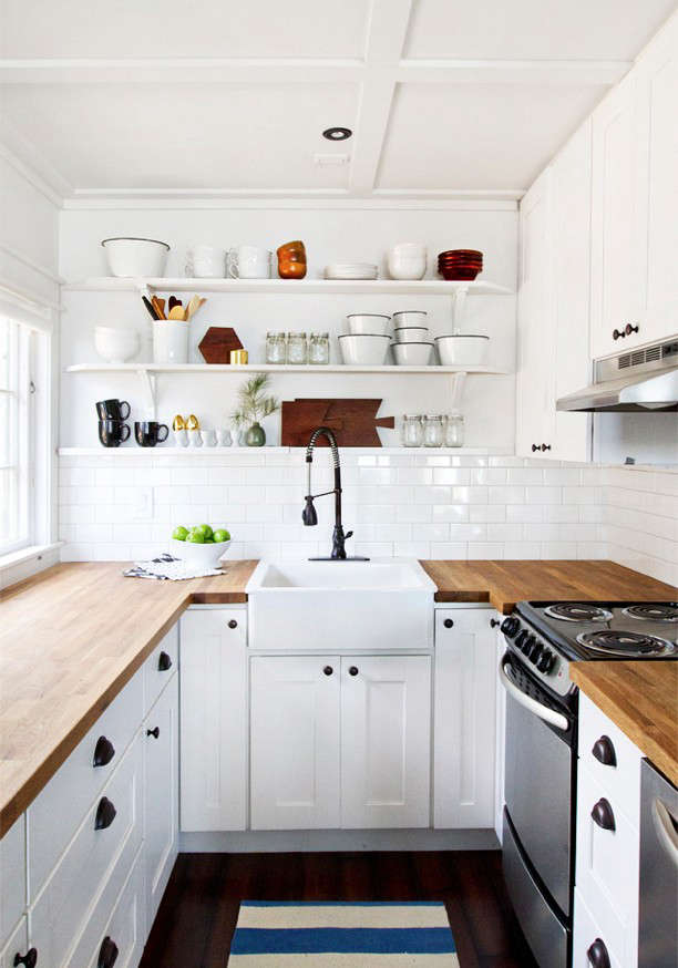A butler’s sink and overhead open shelves provide the focus in designer and blogger Sarah Sherman Samuel‘s small cabin kitchen on the shores of Lake Michigan. (Have a look at Samuel’s newly remodeled kitchen in LA employing what she calls “the ultimate Ikea hack”: Ikea cabinets and custom doors). Photograph via Smitten Studio.