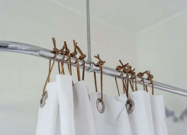 sarah-lonsdale-rental-house-bathroom-leather-shower-curtain-ties-Remodelista
