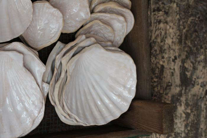 Ceramics are molded from beach shells, then coated in a high-gloss white glaze.