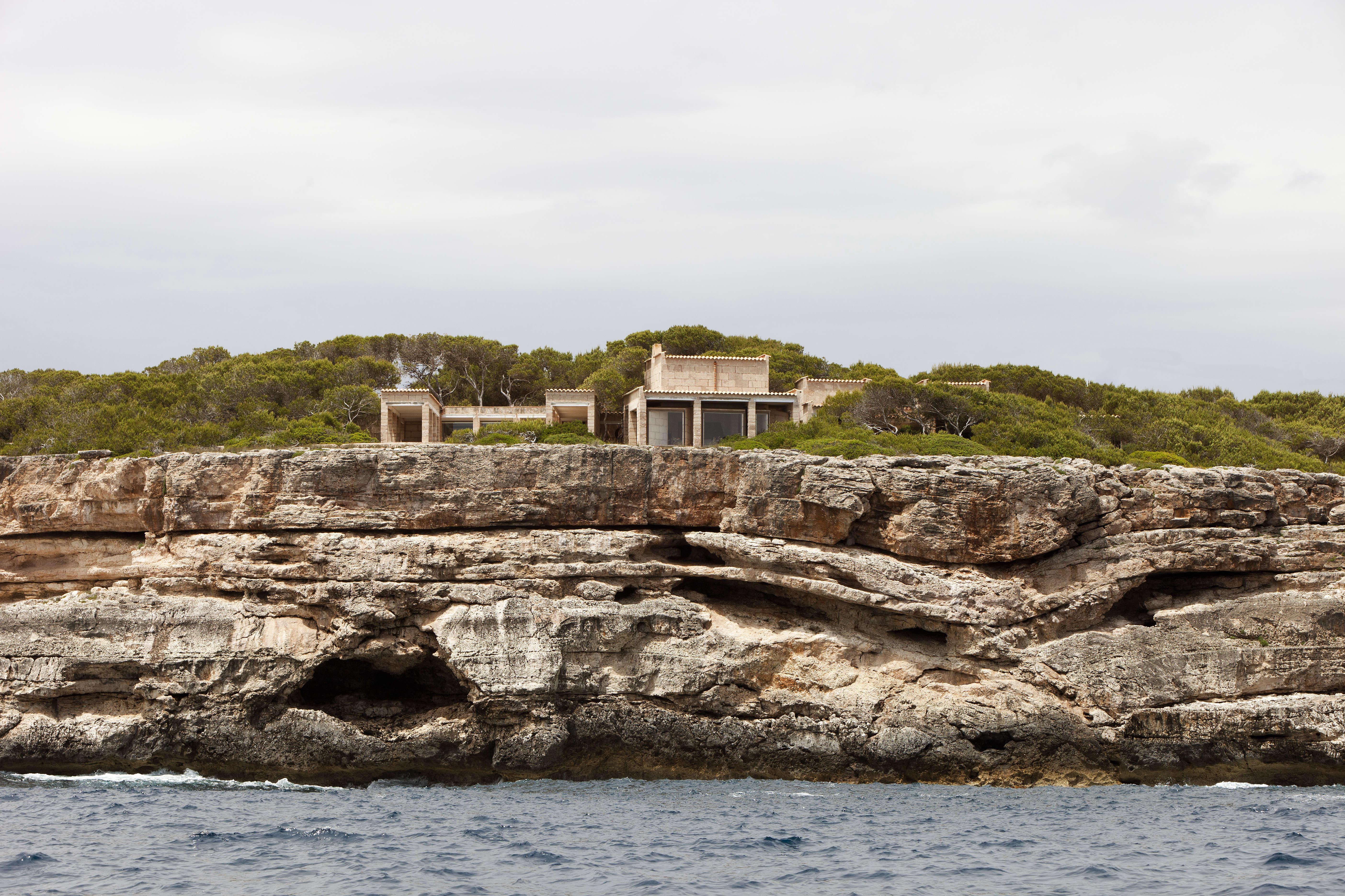 As was the holistic intention of Utzon, the house appears to have cropped up out of the surrounding rock.