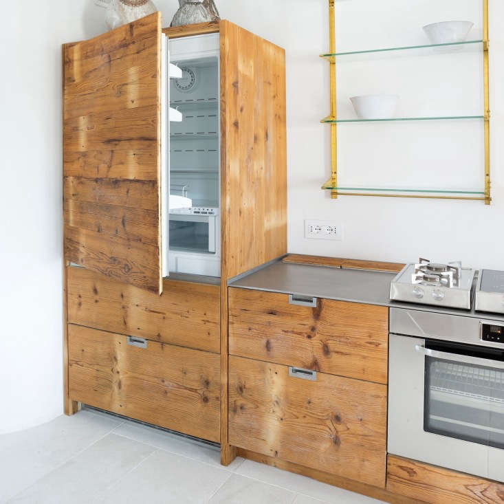 Wood paneled refrigerator in an Italian kitchen made of reclaimed larch wood