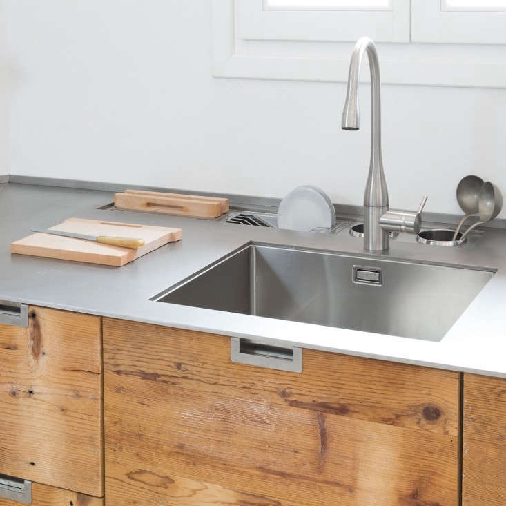 Stainless steel sink in an Italian kitchen made of reclaimed larch wood