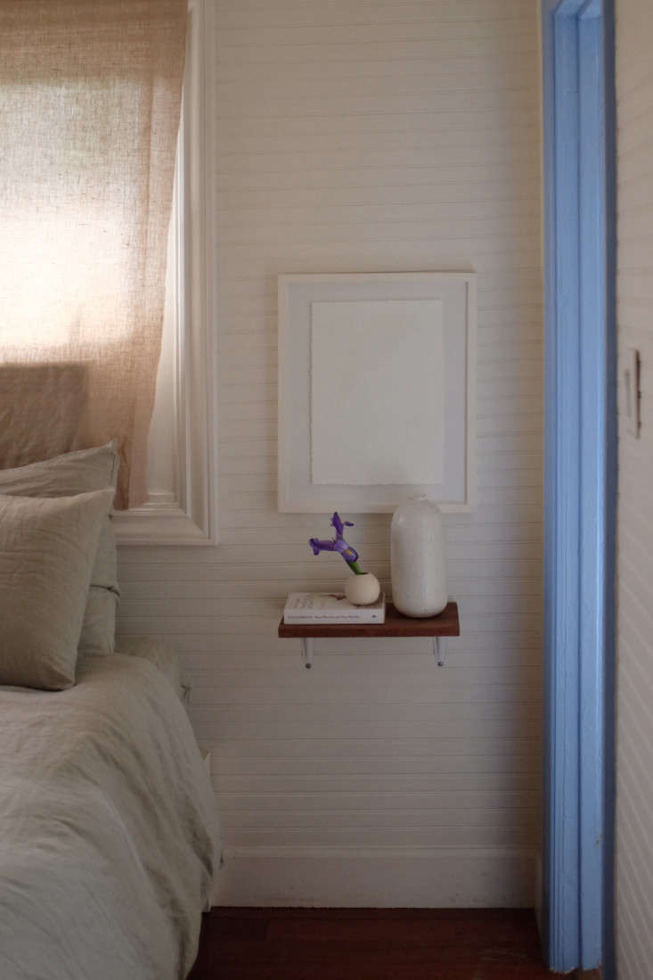 To save space, Alex and Jodi used small shelves in place of nightstands. The bed frame is from Ikea.