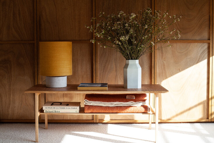 in the primary bedroom, antoine used wood flooring to build cozy wall panels. h 24