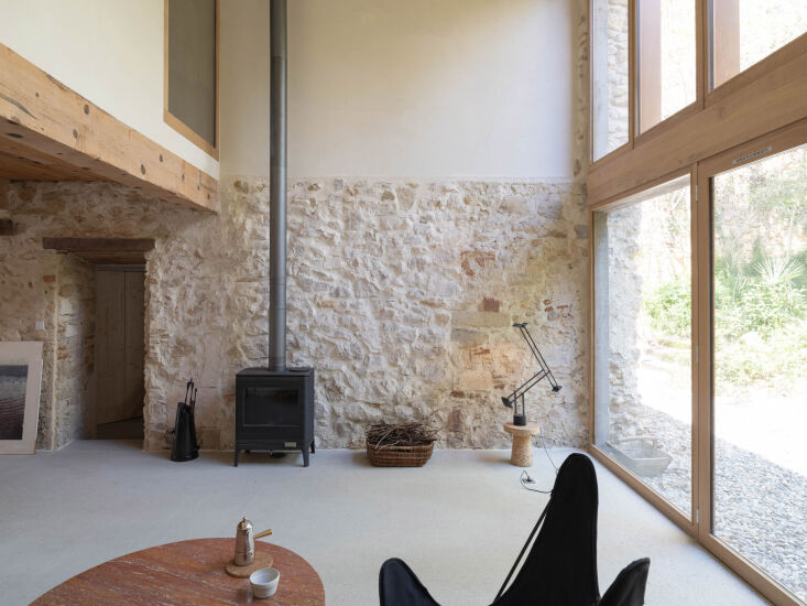 a wide view of the double height volume. the freestanding stove is an invicta k 24