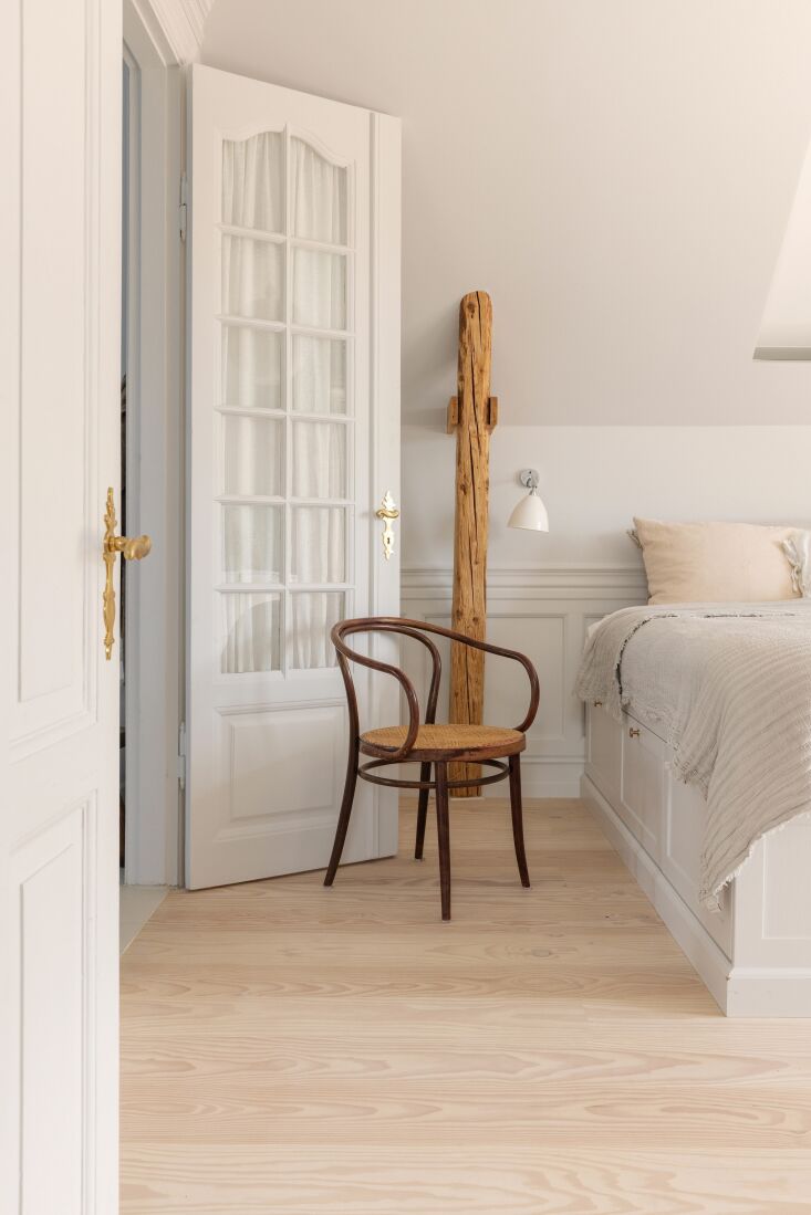 a bedroom with a custom built in bed designed to maximize storage. a gubi wall 24