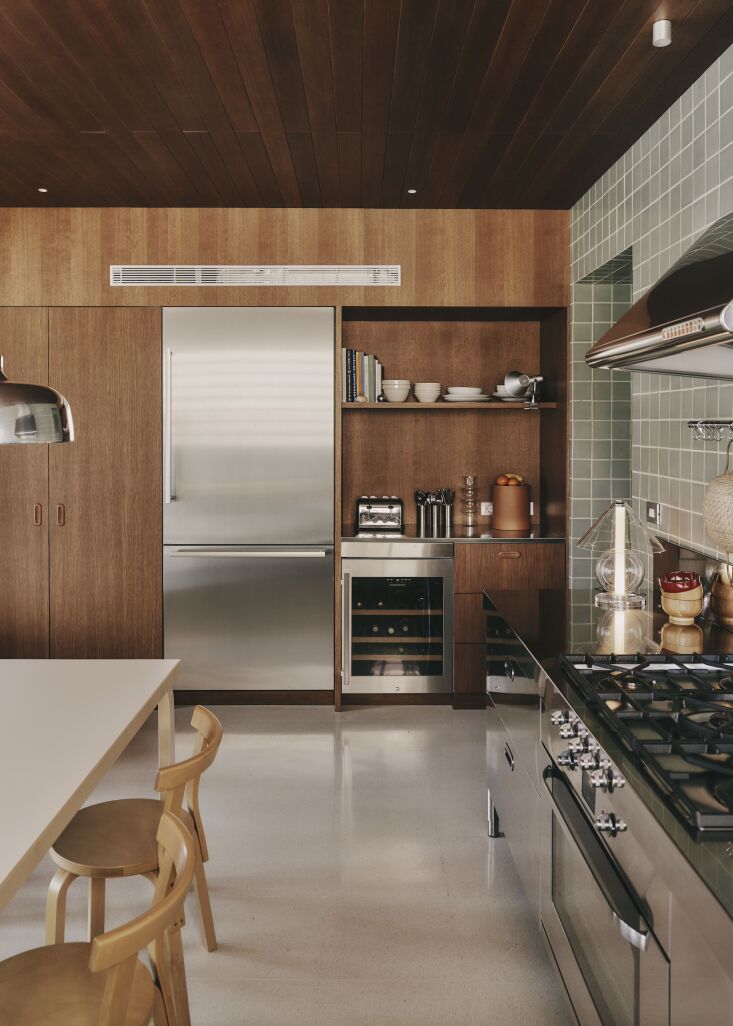 a wood paneled wall and ceiling are warm counterpoints to the metal surfaces. t 21