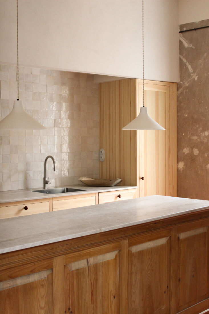 a kitchen designed in reclaimed wood and raw pine with stone counters, zellige  17