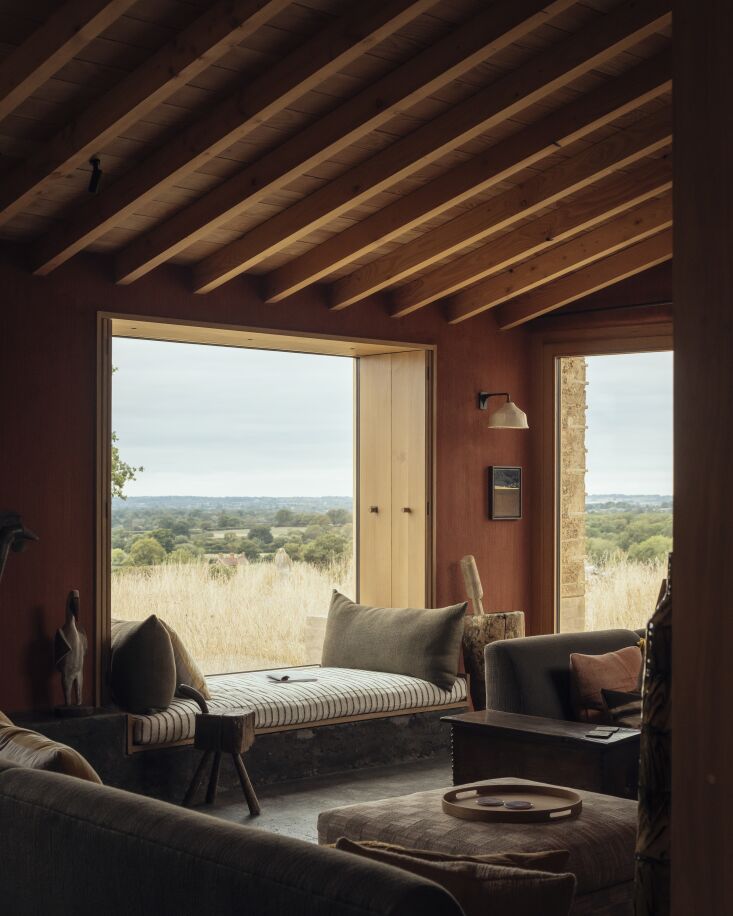 a reading nook window in a room with mahogany stained plaster walls. the wall l 26