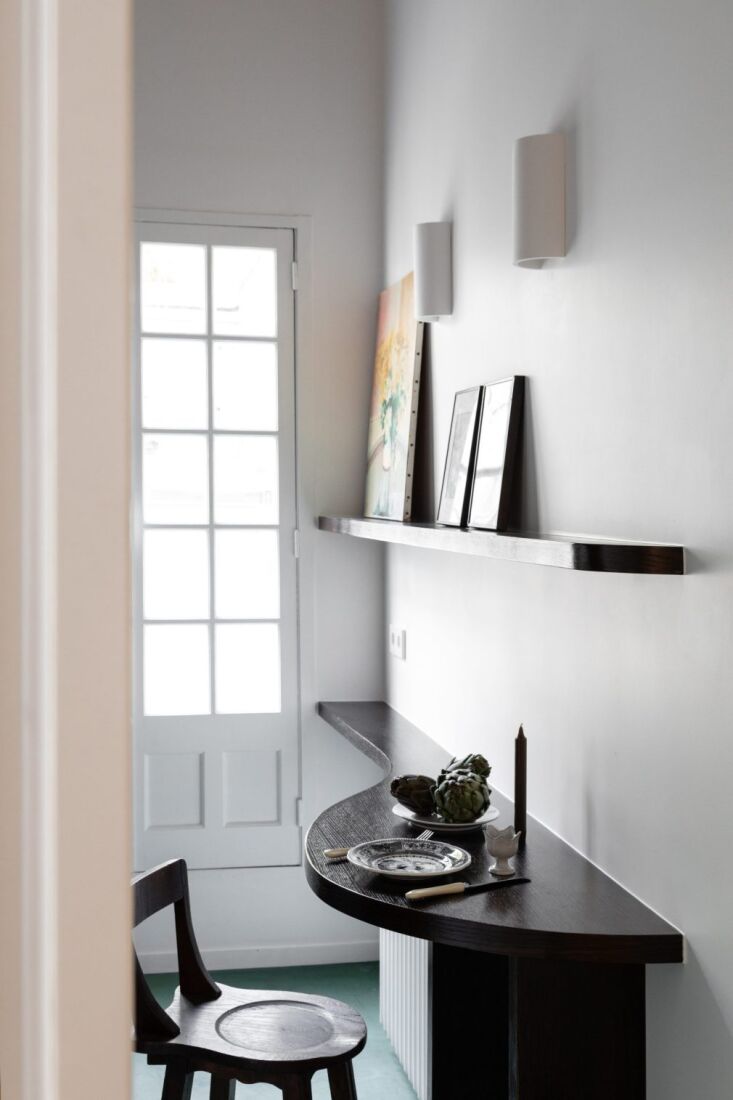 a pair of half cylinder sconces light the kitchen above a small built in table. 18