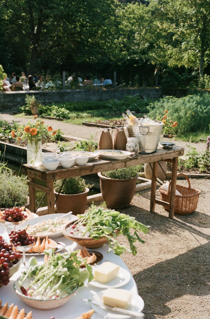 bunches of grapes, sliced melon, and radishes on ice decorate the length of the 23