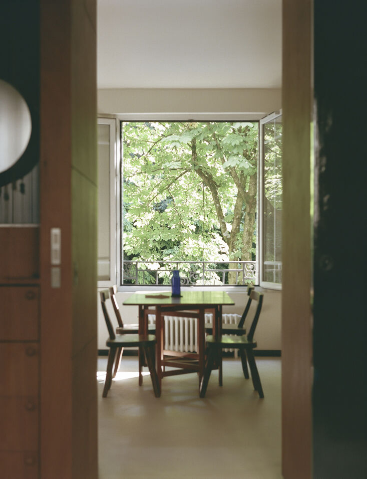 a vintage scandinavian dining table is paired with brutalist chairs. beyond the 24
