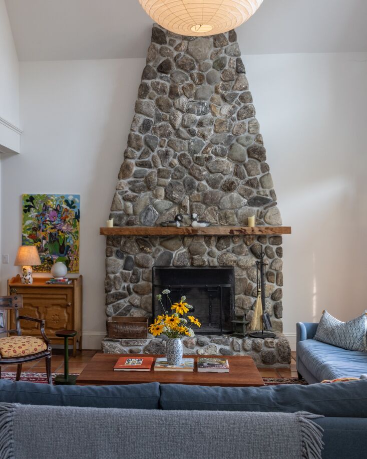 a stone fireplace anchors the living room. the cisco sofas are done in george s 22