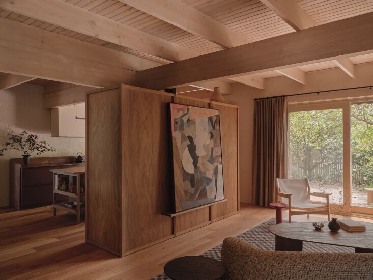 the kitchen is concealed just behind a new wood cabinet that doubles as a parti 19