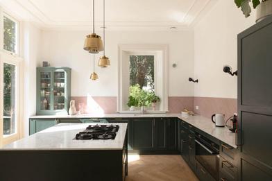 A vintage green kitchen with an island featuring white brick