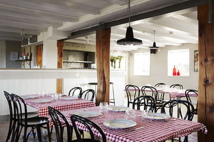 the red and white checkered table clothes add a warm note to the rustic restaur 21