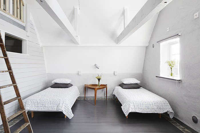 a minimalist white bedroom with two twin beds. 16
