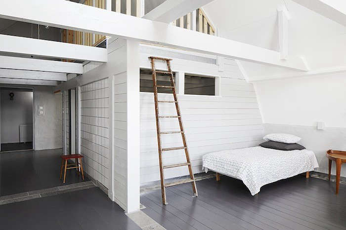 the walls and ceiling of this lofty bedroom are covered in white painted shipla 17