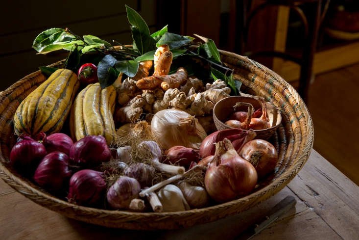 alice keeps a basket of ginger root, shallots, garlic, and herbs on hand at all 22