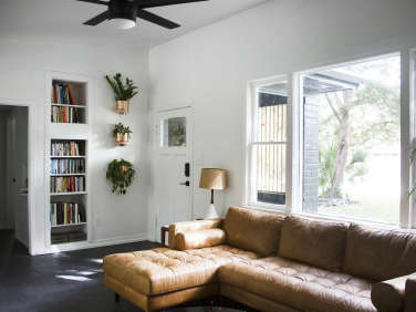 living room brown leather couch plants copper pots  