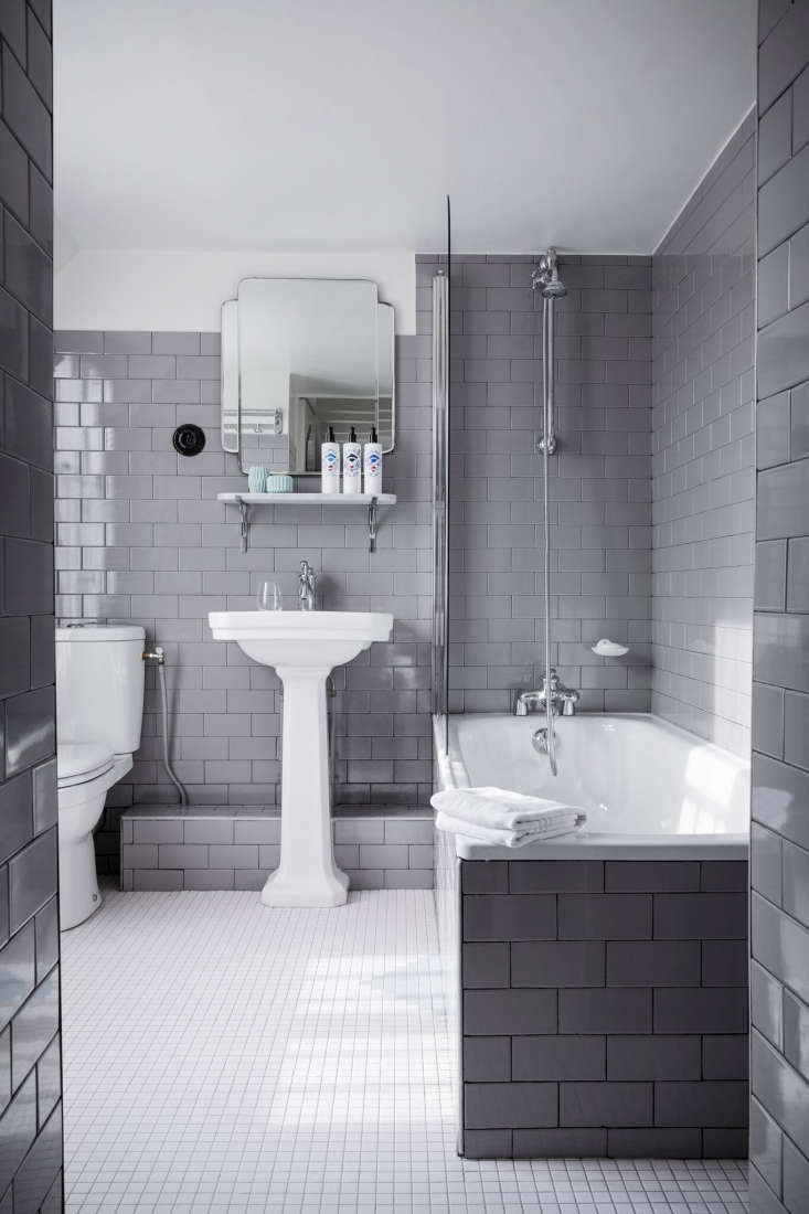 far from outdated: a gray tiled built in bath (with a glass shower wall) at hot 18