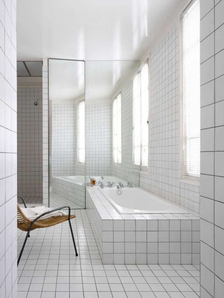an artful built in bath, surrounded in the same tile as the floor and walls, in 21