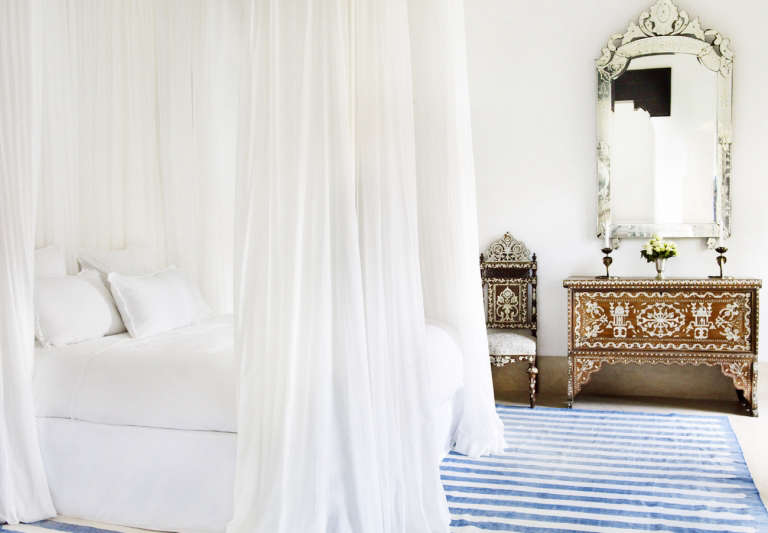 white bed curtains blue white striped rug silver mirror  