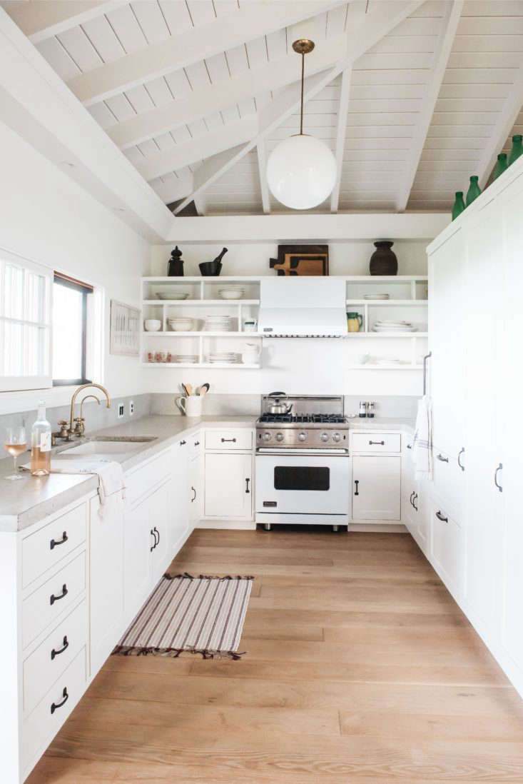 the kitchen features white painted cabinetry and a sliding window above the sin 17