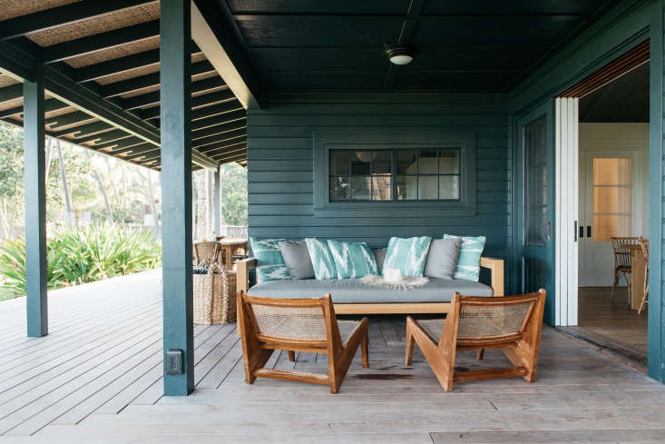 on the wide porch, a lounge area, anchored by two pierre jeanneret ca 13