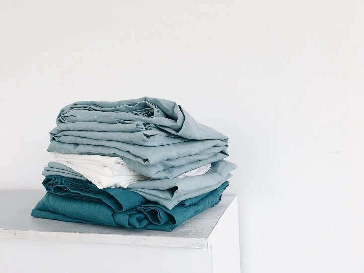 a stack of the linens in sea inspired hues. (bed is &#8\2\20;the sea you di 19