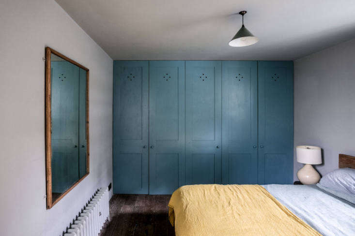 a wall of blue closets anchors this bedroom. 17