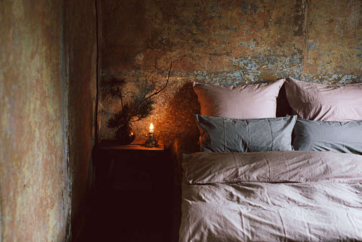 in the spirit of simplicity and imperfection, a bedside is adorned with a forag 19