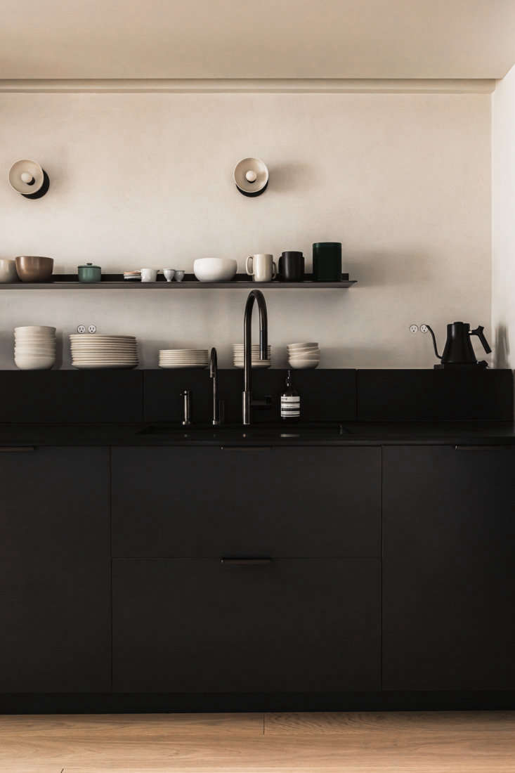 the kitchen, with black cabinetry and counters, is by henrybuilt. the wall behi 10