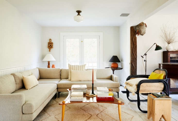 a persimmon candle takes center stage in the eclectic, layered living room of w 14
