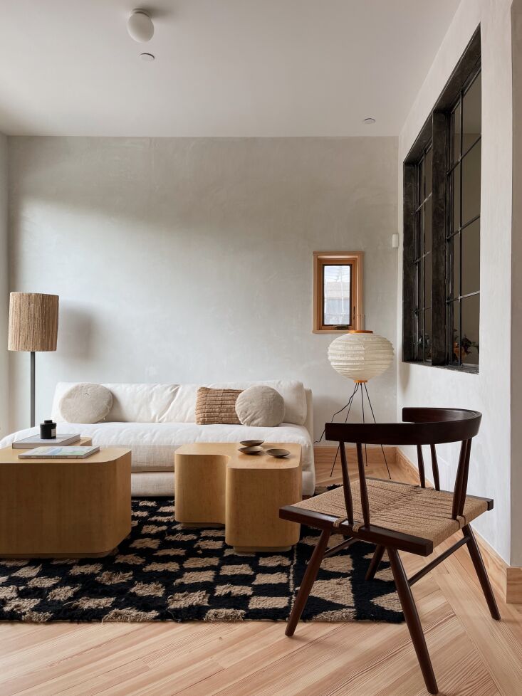 The sitting area is furnished with a CB\2 sofa and Madeline Weinrib rug from ABC Carpet . The interior  steel windows bring light into the bath. Photograph by Hollister Hovey.