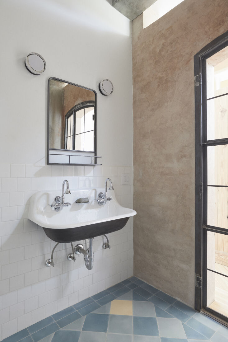 The bath has a double utility sink—the wall-mounted Brockway from Kohler with Kohler&#8\2\17;s Triton Bowe gooseneck spouts—and a floor of cement tiles from Villa Lagoon Tile of Gulf Shores, Alabama.
