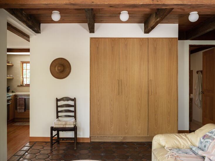 Before and After A Summery Bungalow in Topanga California Redone by an LA Designer &#8220;We also unified interior architectural details, highlighted the views with simple wood windows, and exposed the original wood framing on the doors,&#8221; Tamar writes. The living area features dark wood beams and the original terra cotta tile floor.